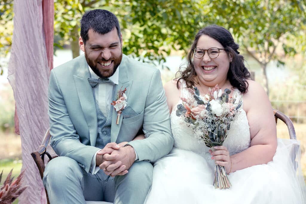 des mariés rigolent à un discours de cérémonie laïque